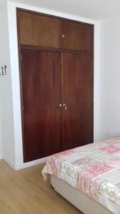 um quarto com um grande armário de madeira ao lado de uma cama em Ótima localização em Águas de Lindoia