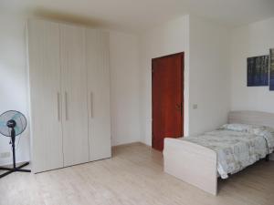 クエルチアネッラにあるLa Quercettaの白いベッドルーム(ベッド1台、クローゼット付)