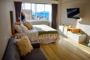a bedroom with a bed and a window and a couch at Patagonia D.A.T in San Carlos de Bariloche