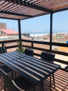 ein blauer Tisch und Stühle auf einer Terrasse mit Strand in der Unterkunft Casa de Playa Arica in Lurín