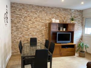 a dining room with a table and a tv at Apartamento El Capricho in Cudillero
