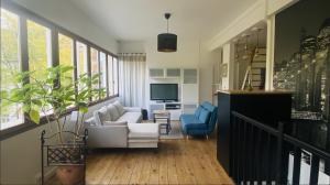 ein Wohnzimmer mit einem Sofa und einem TV in der Unterkunft Exceptionnel au coeur de Lille in Lille