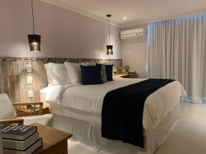 a bedroom with a large bed in a room at Hotel Experience João Fernandes in Búzios