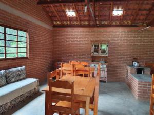 a room with a table and chairs and a brick wall at Chalé, Recanto da Natureza in Gonçalves