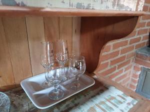 four wine glasses sitting on a tray on a shelf at Chalé, Recanto da Natureza in Gonçalves +28 photos