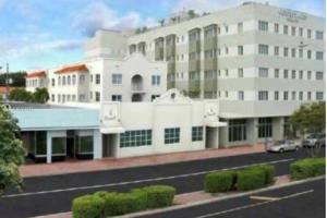 un gran edificio blanco con una calle delante en SOBE SUNSHINE ONE BEDROOM APARTMENTs, en Miami Beach