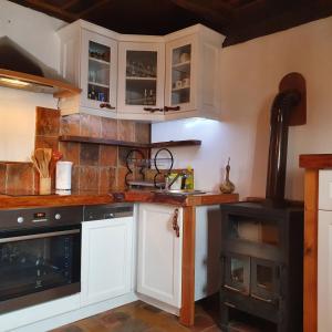 a kitchen with white cabinets and a stove at Domus Antiqua in Gornja Voća