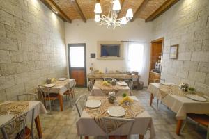 een eetkamer met tafels en stoelen en een kroonluchter bij Vicolo del Porto in Lampedusa