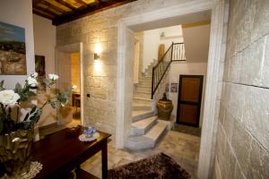 a living room with a stone wall and a staircase at Vicolo del Porto in Lampedusa