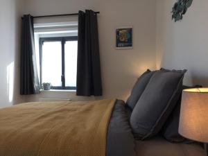 1 dormitorio con cama y ventana en Entre terre et mer en Montfarville