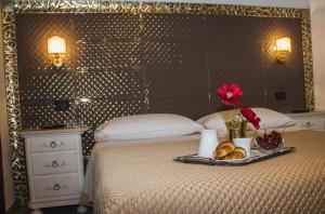 een bed met een dienblad met brood en bloemen erop bij Vicolo del Porto in Lampedusa