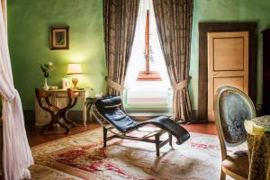 een woonkamer met een stoel en een raam bij Villa Il Fedino in San Casciano in Val di Pesa