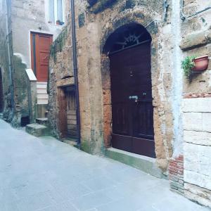 un vicolo con due porte marroni su un edificio di La Dolce Vita Fidardo a Pitigliano