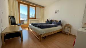 Pokój z kanapą, biurkiem i oknem w obiekcie Alberti 5 w Davos