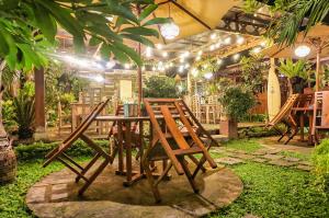 drewniany stół i krzesła w ogrodzie w obiekcie The Wisma Pulau Merah w mieście Pasanggaran