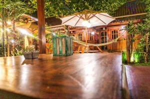 un tavolo in legno con ombrellone in un ristorante di The Wisma Pulau Merah a Pasanggaran