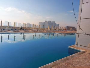 a pool of blue water with a city in the background at Exclusive Creek Bay Apartment in Ajman 