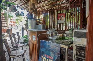 un ristorante con sedie e un bancone con un vaso sopra di Wisma Pulau Merah a Pasanggaran