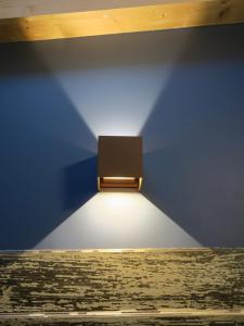 a light in a room with a blue wall at Foresteria Conti, sulle tracce di Shakespeare in Padova