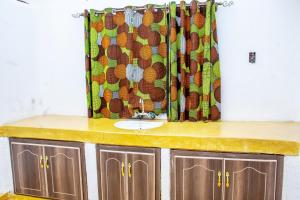 a bathroom with a sink and a shower curtain at Etana Cottage in Kakamega