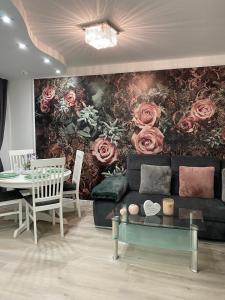 een woonkamer met een bank en een rozenmuurschildering bij RoseMarie in Gotha