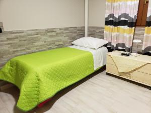 a bedroom with a bed with a green blanket at VILLA DEI CICAS in Taranto