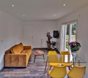 una sala de estar con un sofá y sillas en Maison Blanche en Côte de Nacre, en Mathieu