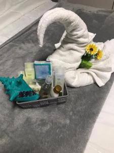ein Tablett mit Pflegeprodukten auf einem Bett und einem Handtuch in der Unterkunft Aruba2023 in Oranjestad
