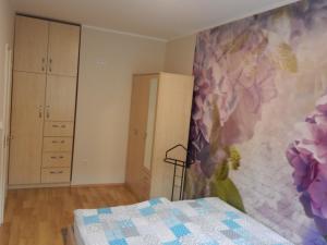 a bedroom with a flower mural on the wall at Boros Apartman in Kőszeg