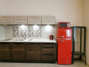 uma cozinha com um frigorífico vermelho e um lavatório em Little Big Red - Central Modern Studio em Cracóvia