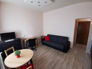 uma sala de estar com um sofá e uma mesa em Little Big Red - Central Modern Studio em Cracóvia