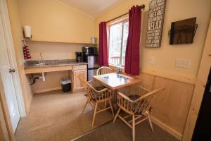 a kitchen with a table and chairs and a window at McKinley Creekside Cabins in McKinley Park