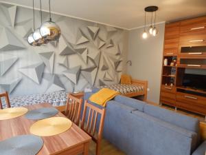 Boros Apartman في كوسيغ: غرفة معيشة مع أريكة زرقاء وطاولة