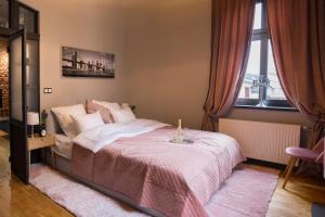 1 dormitorio con 1 cama grande con manta rosa en Apartament Podcienie z tarasem Bielsko-Biała Old Town en Bielsko-Biala