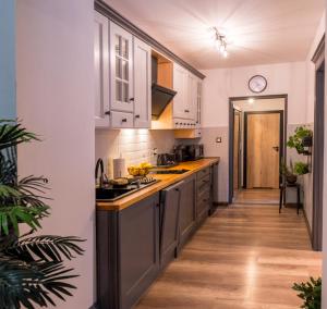 a kitchen with white cabinets and a wooden floor at Apartament Podcienie z tarasem Bielsko-Biała Old Town in Bielsko-Biała