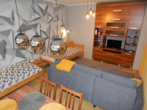 uma sala de estar com um sofá azul e uma sala de jantar em Boros Apartman em Kőszeg