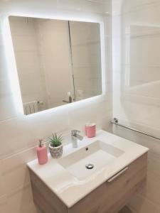 La salle de bains blanche est pourvue d'un lavabo et d'un miroir. dans l'établissement 30 mètres de la plage et des planches. Tout à pied !, à Trouville-sur-Mer