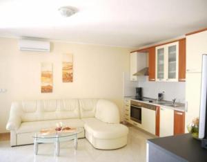 een woonkamer met een witte bank en een tafel bij Villa del Golfo in Savudrija