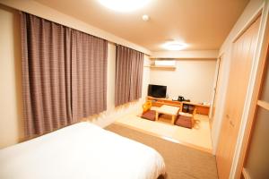 A bed or beds in a room at Dormy Inn Akita