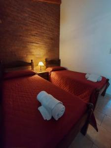a hotel room with two beds with towels on them at Las Retamas - Viviendas Turísticas in Zapala