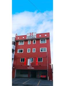 ein rotes Gebäude mit einem Schild darüber in der Unterkunft HOTEL VITTORIA in San Felipe Hueyotlipan