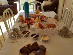 uma mesa com pequeno-almoço de pão e sobremesas em Cabana da Colina em Bom Jardim da Serra