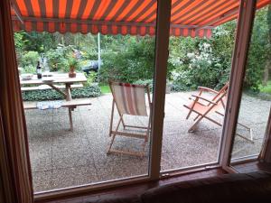 a view of a patio with a table and chairs at Holiday Home in Gemmenich with Forest Views in Ten Eiken