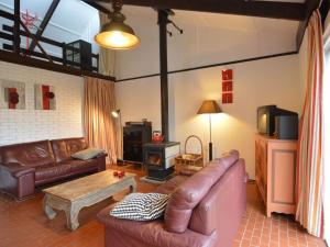 uma sala de estar com um sofá de couro e uma mesa em Holiday Home in Gemmenich with Forest Views em Ten Eiken