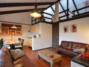 sala de estar con sofás, mesa y cocina en Holiday Home in Gemmenich with Forest Views, en Ten Eiken