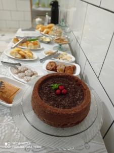a chocolate cake on a table with other foods at Pousada Casa Verde in Aparecida