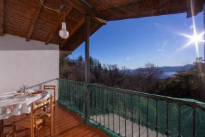 a deck with a table and chairs on a balcony at Villa La Verbanina Private Garden - Happy Rentals in Ghiffa