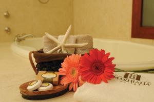 - une salle de bains avec une serviette et une fleur sur un comptoir dans l'établissement Marhialja Hotel Boutique, à Oaxaca