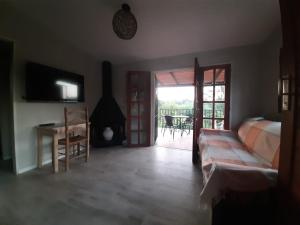 1 dormitorio con cama, escritorio y balcón en Hermosa casa frente al rio icho cruz 10 personas en Villa Icho Cruz