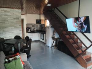 a living room with a tv and a table and a kitchen at Winterville Gravatá Flat 1011 in Gravatá